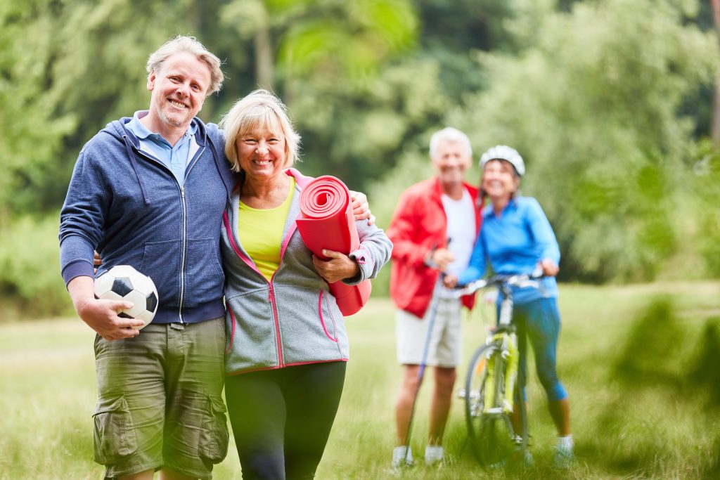 Vitales Senioren Paar und sportliche Freunde zusammen im Sommer im Park